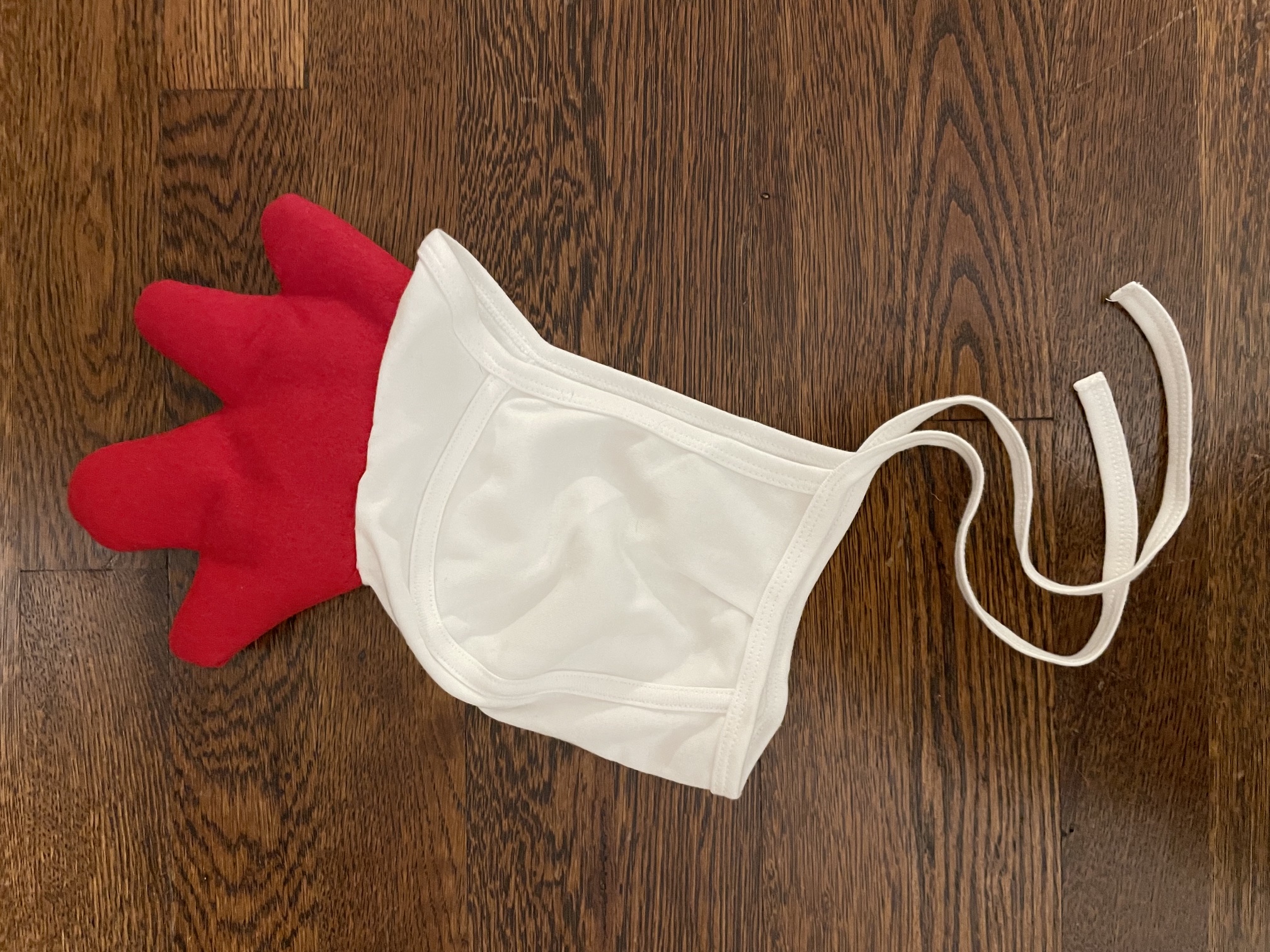 White bonnet with a stuffed red felt chicken comb attached