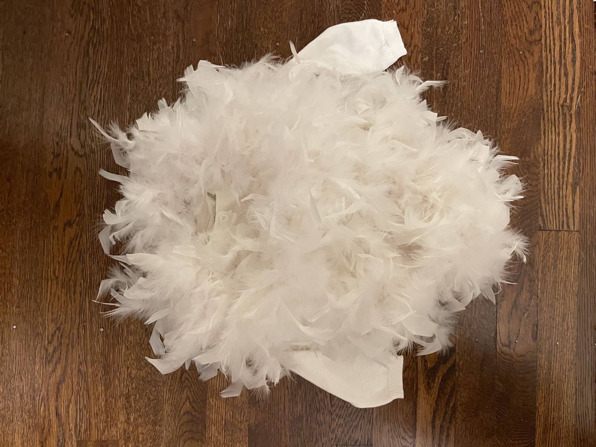 White cardigan with both feather boas wrapped around the bodice