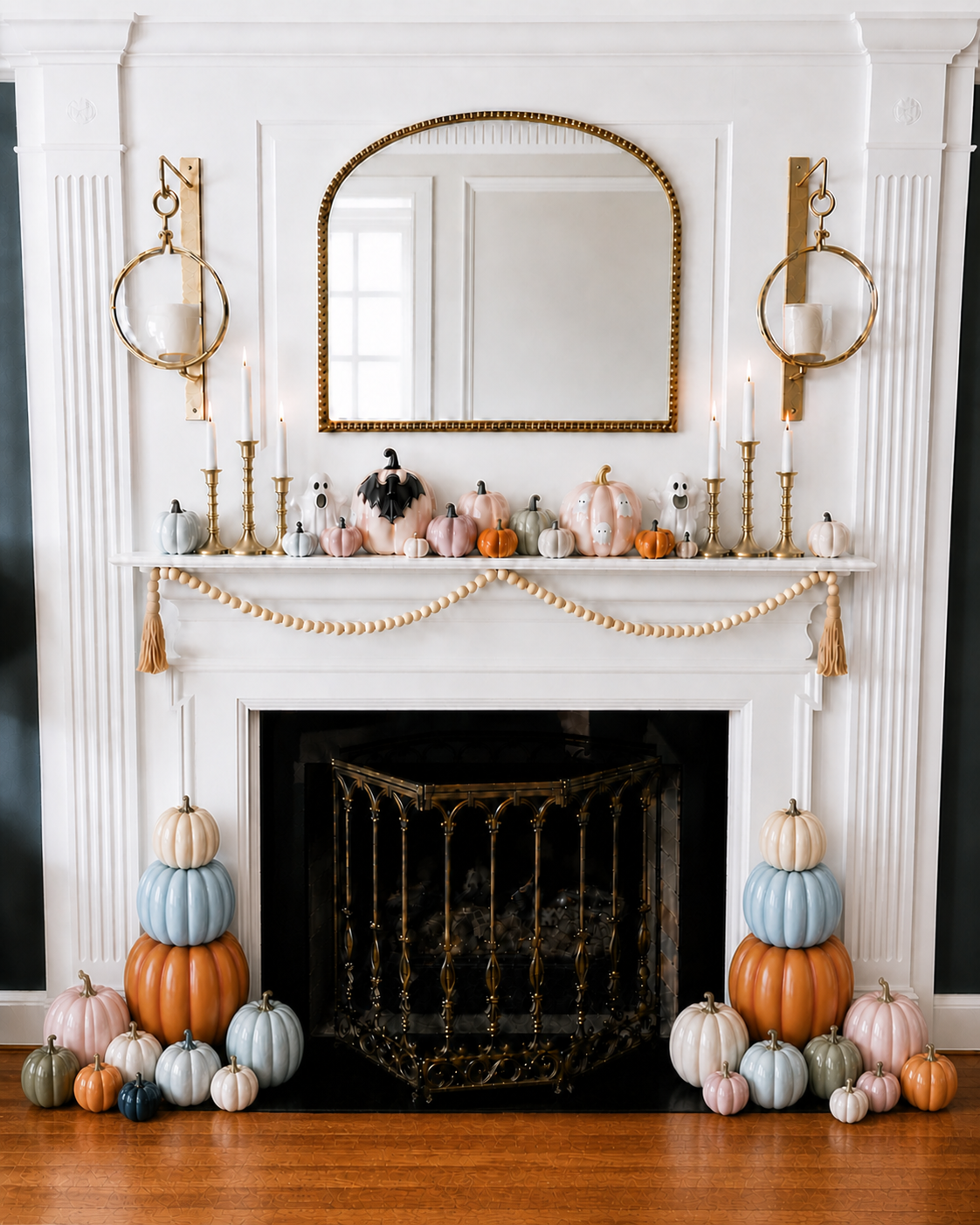 Pastel pink, blue, ivory, sage, and orange pumpkins styled around a Halloween fireplace