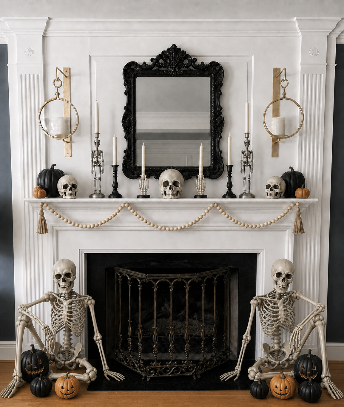 Two seated skeletons flank a simple Halloween mantel with skulls, black pumpkins, and candles
