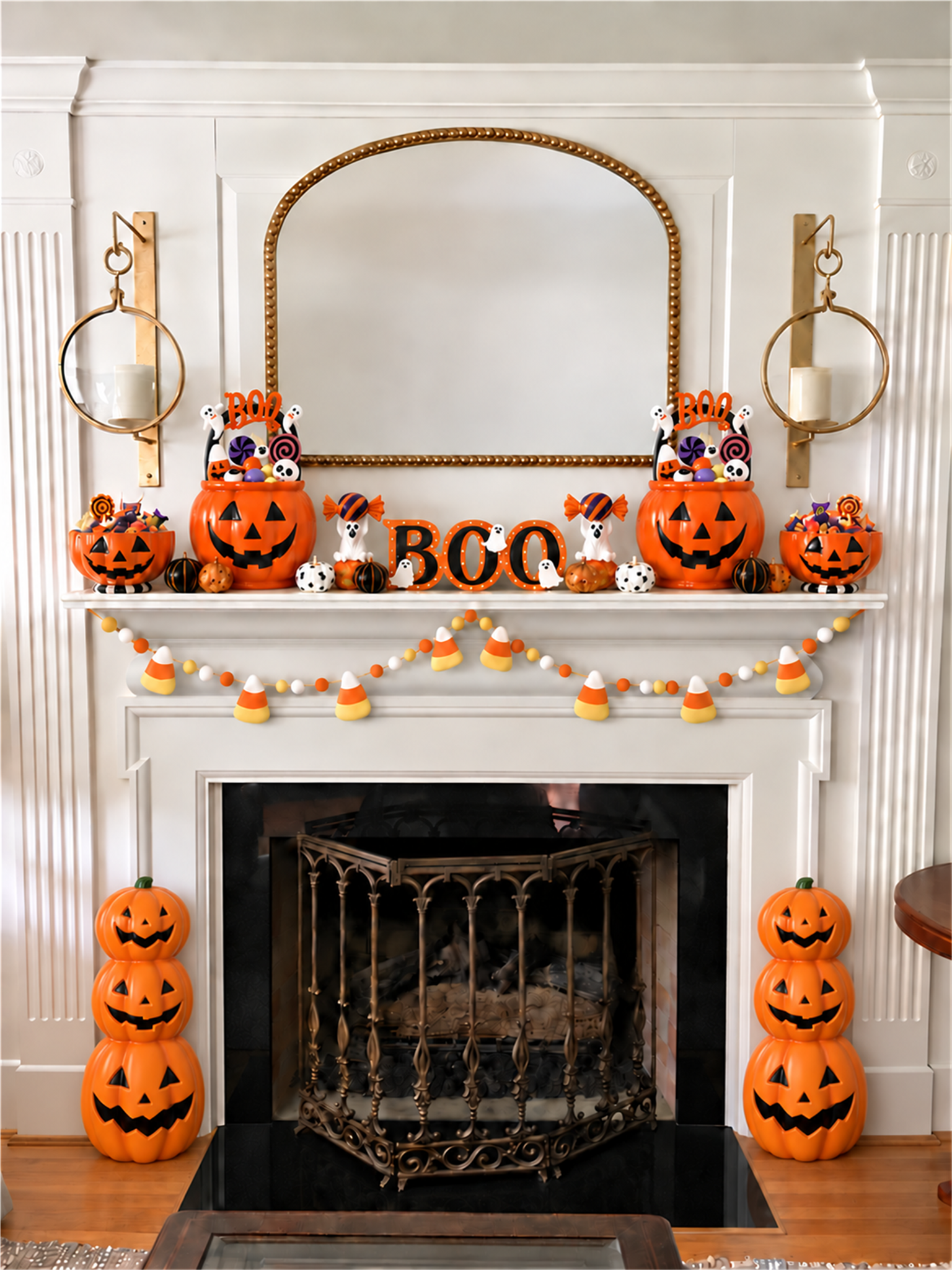 Trick or Treat fireplace with pumpkin candy bowls, BOO buckets, ghost figurines, and candy corn garland